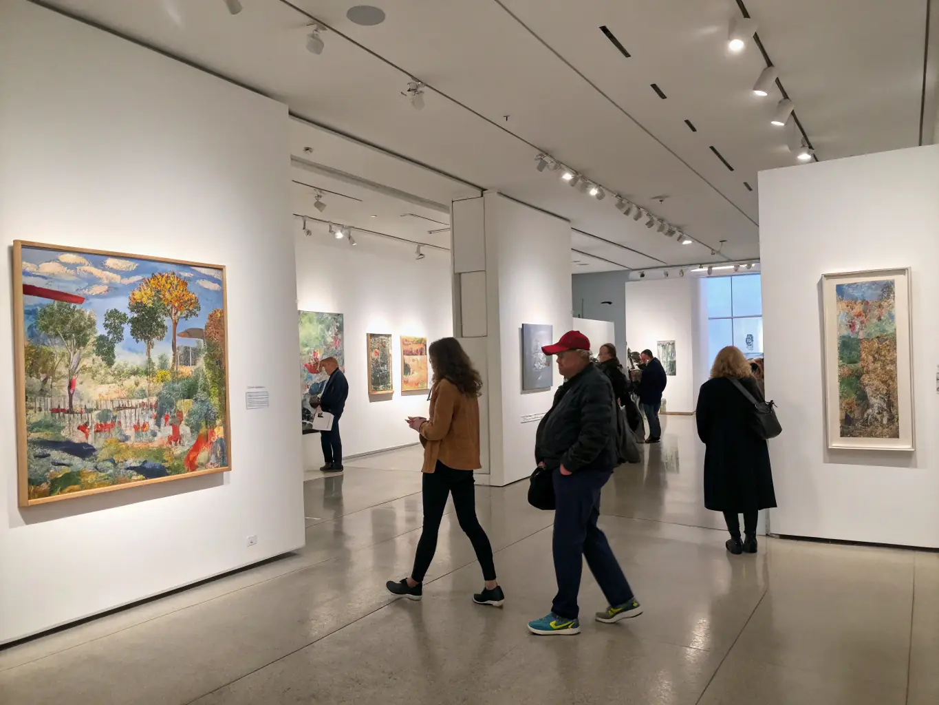 An exhibition showcasing diverse artworks, highlighting the talent and creativity fostered by LA COUR DES ARTS, with visitors admiring the pieces.